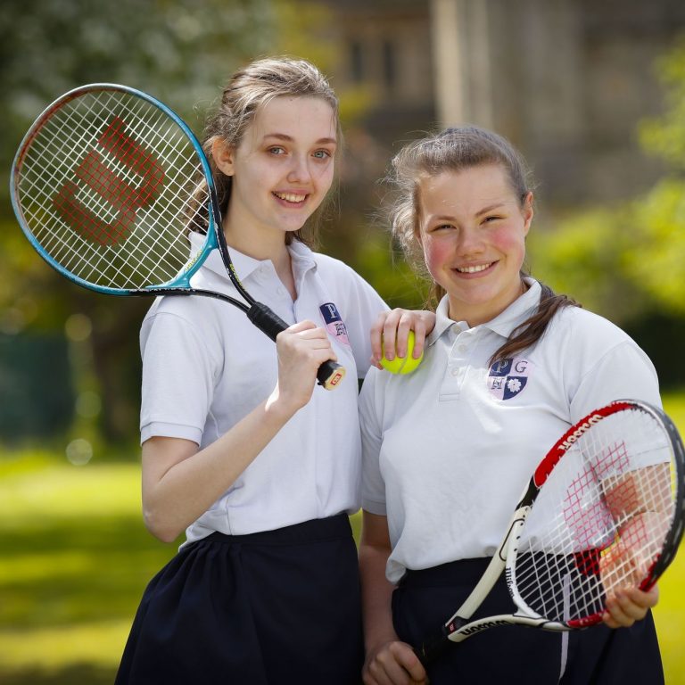 girls holding tennis rackets