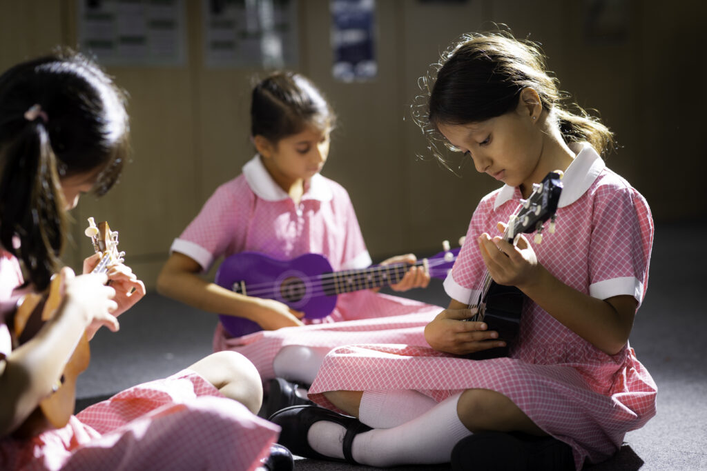 students playing on ukuleles